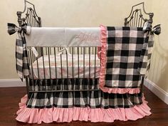 a black and white checkered crib bedding set with pink ruffles