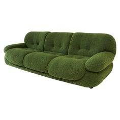 a green couch sitting on top of a white floor