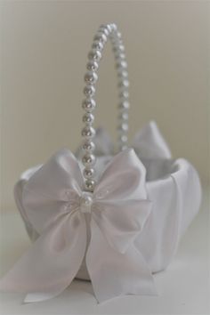 a white basket with pearls and a large bow