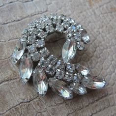 Authentic 50's Rhinestone Crystal Stone Brooch Pin, 1950's Glamor Rhinestone Jewelry, Night Evening Event Gala Wedding Cocktail Hour Fancy Dress Brooch, lovely bright Austrian Crystals, white/silver tone metal, solder puddles, not signed by designer quality, good working roll over clasp, the best rhinestone jewelry has stones set by hand and prong secured, like this piece.  Iconic form shape style  1950's, even late 40's in style   2 IN x 1 3/4 IN  Lovely  Authentic period rhinestones Retro Wedding Brooches With Rhinestones, Vintage Crystal Brooches For Anniversary, Vintage Anniversary Brooch With Sparkling Stones, Vintage Sparkling Wedding Brooches, Wedding Cocktail Hour, Dress Brooch, Cocktail Hour Wedding, Brooch Dress, Wedding Cocktail