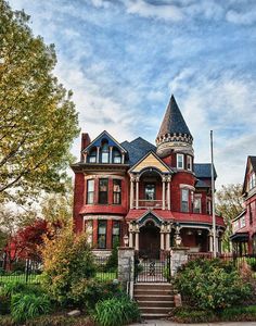 an old victorian style house with red and yellow trim