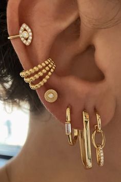 three different ear piercings on the back of a woman's head, one is gold