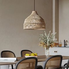 a dining room table with chairs and a basket hanging from the ceiling