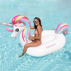 a woman sitting on an inflatable unicorn float floating in the water with her legs crossed