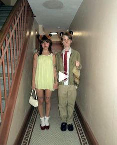 two people in costumes are standing on the stairs