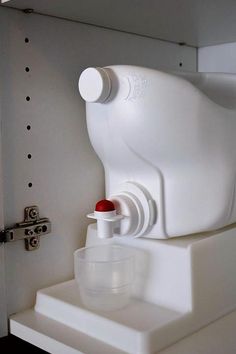 a water dispenser sitting on top of a white shelf