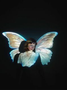 a woman wearing a butterfly costume in the dark