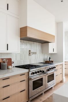 a stove top oven sitting inside of a kitchen next to wooden cabinets and counter tops