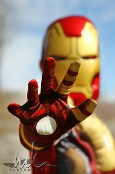 a close up of a toy iron man with his hand in the shape of a heart