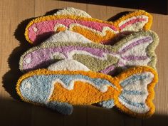 three colorful rugs sitting on top of a wooden floor