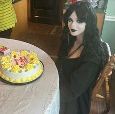 a woman sitting at a table with a cake on it