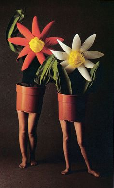 two people standing next to each other with fake flowers in them