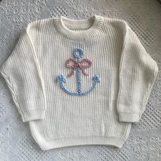 a white sweater with an anchor on it