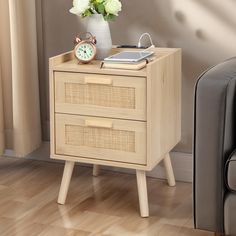 a small wooden table with two drawers and a clock on it next to a chair