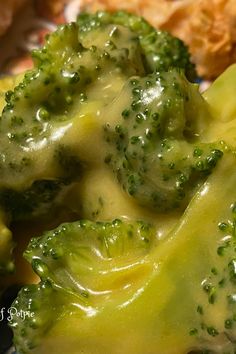 broccoli covered in cheese and sauce on a plate