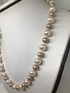 This two tone pearl necklace is hand knotted with white silk thread using 8mm Swarovski powder almond and 10mm Swarovski cream rose pearls at a classic length of 20 inches. These two colors compliment each other with soft pink tones. NOTE: See pic #2 outside photo of necklace for a better color description. I have finished this statement necklace with a sterling silver filigree fishhook pearl clasp. FREE sterling silver stud earrings in matching 8mm cream rose pearls included!! This necklace wil Elegant Single Strand Cream Pearl Necklace, Elegant Cream Single Strand Pearl Necklace, Cream Pearl Drop Necklaces With Round Beads, Cream Single Strand Pearl Necklace, Cream Pearl Drop Necklace With Round Beads, Beige Pearl Necklace Gift, Cream Jewelry With Pearl Charm And Round Beads, Cream Single Strand Jewelry With Round Beads, Cream Pearl Chain Jewelry With Round Beads