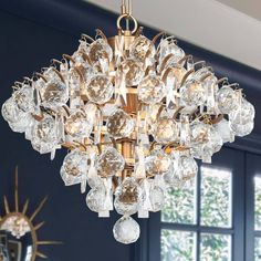 a chandelier hanging from the ceiling in a room with blue walls and windows