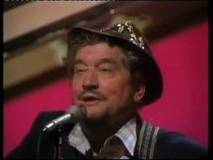 a man with a crown on his head singing into a microphone