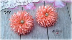 two pink flowers sitting on top of a wooden table