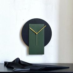 a black and green clock sitting on top of a table