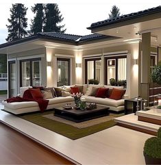 a living room filled with furniture next to a large glass doored entrance way at night