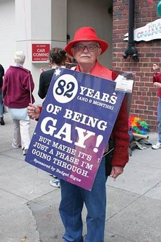 an older woman holding a sign that says, 39 years of being gay but maybe it's just a phase i'm going through