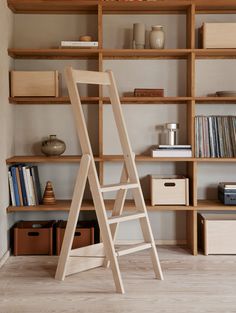 a ladder leaning up against a bookshelf in a room with wooden boxes and other items