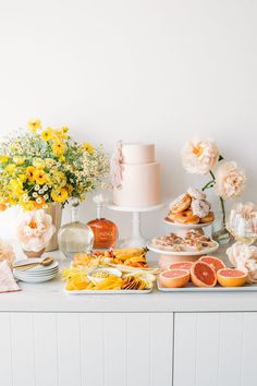 a table topped with lots of different types of food and flowers on top of it