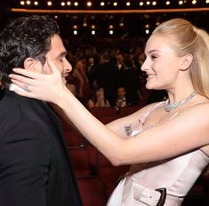 a man in a tuxedo is hugging a woman's neck at an event