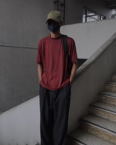 a man standing on the stairs with his back to the camera and wearing a face mask