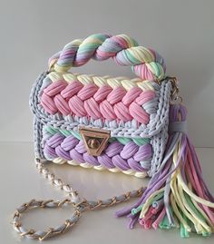 a multicolored handbag with a tasselled handle and chain attached to it