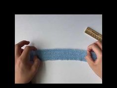 someone is crocheting the edge of a piece of blue yarn with a ruler