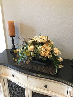 a vase filled with flowers sitting on top of a dresser