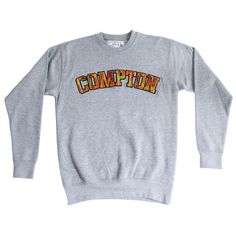 Say it with your chest--C-O-M-P-T-O-N! This comfy premium crewneck sweatshirt makes a bold statement with its big, vibrant Kente cloth letters. The hand-laid embroidery in tackle twill stitching ensures durability while adding an authentic cultural touch. Designed for all-day wear, this soft crewneck sweatshirt is as comfortable as it is stylish. Take pride in your roots, representing the culture and the city wherever you go, without saying a word. Features - Bold Compton kente cloth embroidery with hand-laid tackle twill stitching - Comfortable, soft premium fabric, perfect for all-day wear - Available in multiple colors including black, grey, and green Clothing Specs 8.5 oz. 3-end fleece. 65% cotton/35% polyester* (*Exceptions: Grays: 55% cotton/45% polyester). 100% cotton face. Soft-was Varsity Crew Sweatshirt With Logo Print, Collegiate Crew Neck Sweatshirt With Logo, Heavyweight Letter Print Sweatshirt For Fall, Varsity Sweatshirt With Lettering For Streetwear, Crew Sweater With Lettering For Streetwear, Crew Neck Sweater With Lettering For Streetwear, Sporty Crew Neck Sweater With Lettering, Cloth Embroidery, Kente Print