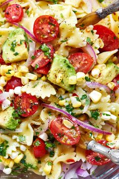 a bowl full of pasta salad with tomatoes and broccoli