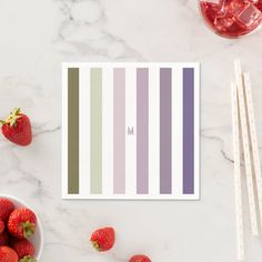 strawberries and ice cream on a marble table next to striped stickers with the letter m