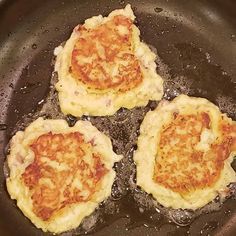 three small pizzas cooking in a frying pan