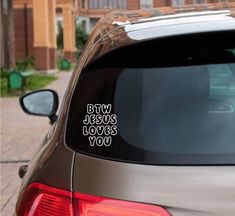 a car with the words buy jesus loves you on it's side window sticker