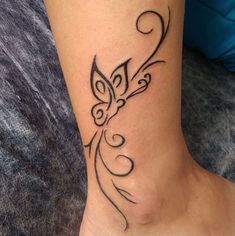 a woman's foot with a butterfly tattoo on the side of her leg,