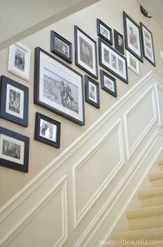 a staircase with pictures on the wall and framed photos hanging on the wall above it