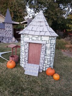 some pumpkins sitting in front of a small house