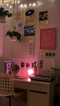 a desk with a laptop computer on top of it next to a potted plant