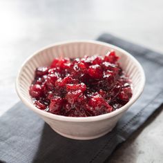 a white bowl filled with cranberry sauce on top of a napkin