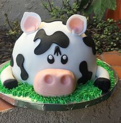 a cake shaped like a cow sitting on top of green grass