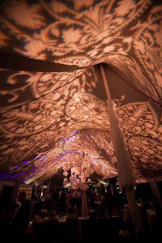 the ceiling is covered in lights and fabric with an intricate design on it's side