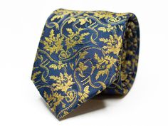 A navy blue tie with a gold floral pattern is a sophisticated and elegant accessory that adds a touch of style and refinement to any outfit. Size: 7.5cm wide (2.95in) Color: Navy blue and gold Pattern: Floral These neckties are dry clean only. Our shop has a huge selection of ties, pocket squares, cufflinks and other suit accessories. For more of our suit accessories, please visit our shop: https://www.etsy.com/ca/shop/GentlemensEra If you have any questions or concerns, please contact us and we will be able to assist you. Instagram: https://www.instagram.com/the.gentlemens.era If you need your order on a certain date, please message before ordering to ensure your order arrives on time. Luxury Gold Tie For Formal Occasions, Elegant Blue Suit And Tie Accessories For Wedding, Luxury Fitted Ties For Wedding, Groomsmen Tie, Groomsmen Ties, Groom Ties, Navy Blue Tie, Suit Tie, Wedding Tie