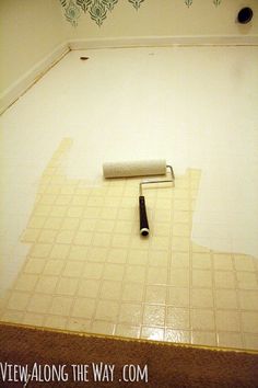 a roller is laying on the floor in a room with white tiles and green wallpaper