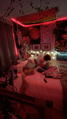 a person laying on a bed in a room with red lights and posters above it