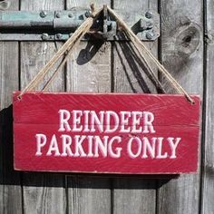 a red sign hanging from the side of a wooden fence that says reminder parking only