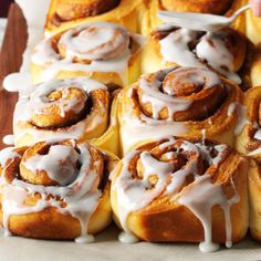 a tray filled with cinnamon rolls covered in icing